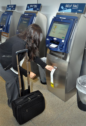 Alaska Airlines bag tags using a dedicated self-tag check-in kiosk