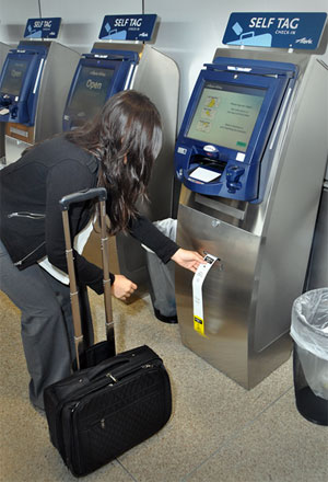 Alaska Airlines bag tags using a dedicated self-tag check-in kiosk Alaska Airlines bag tags using a dedicated self-tag check-in kiosk