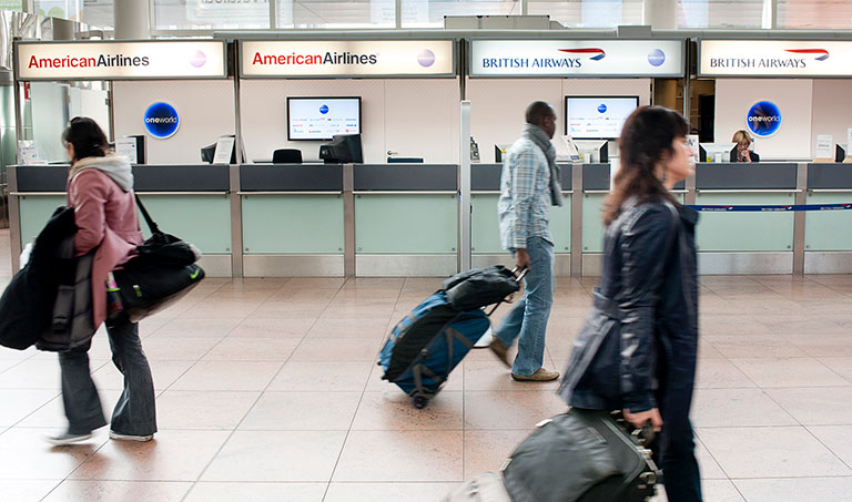 Photograph of passengers passing through airport terminal. 