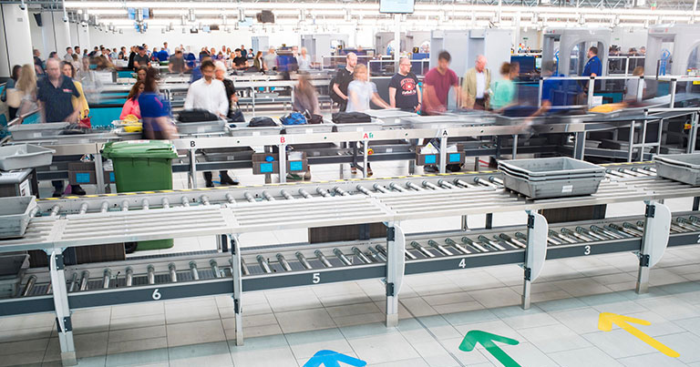 Photograph of passengers collecting items after security screening